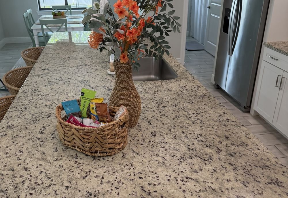 Vacation rental kitchen staged with a welcome basket and fresh flowers for guests